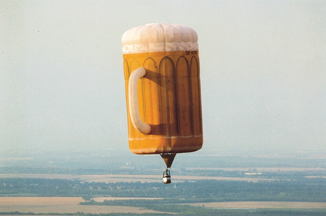 Heißluftballon in Form eines überdimensionalen Bierkrug am Himmel